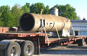 A locomotive boiler sitting on a flatbed truck.